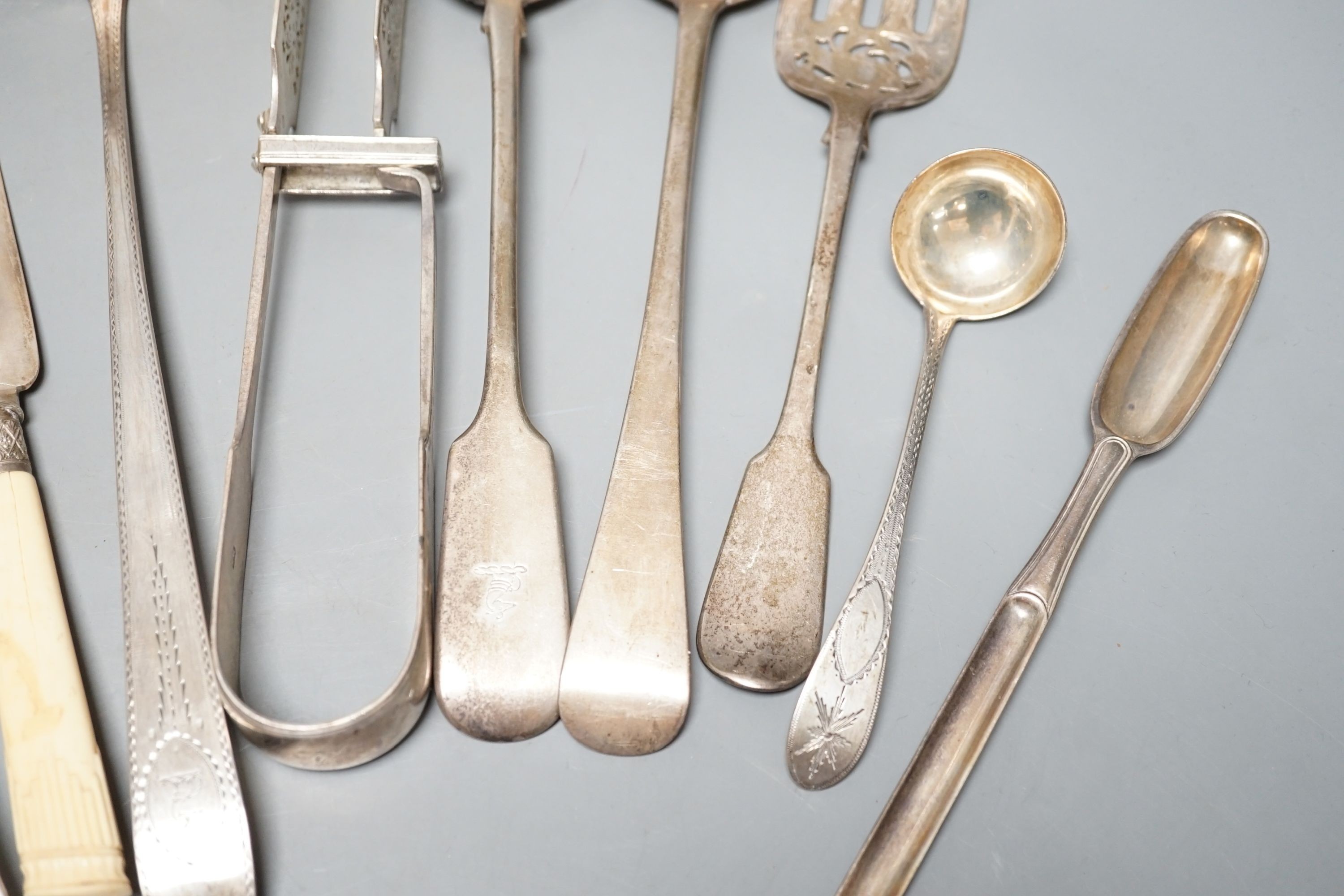 A George III Irish silver Celtic tip soup ladle, Dublin, 1789, A Georgian Irish silver marrow scoop, by William Walsh, two later Victorian silver soup ladles, a pair of Victorian silver asparagus tongs, two silver bastin